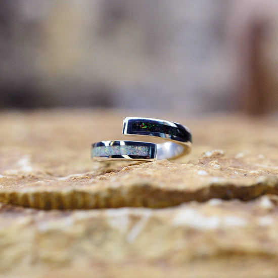 Opals & Ashes Dual Spiral Memorial Ring. Sterling Silver, Perl white & black fire opals blended with our customers loved one’s ashes. Photographed on rock