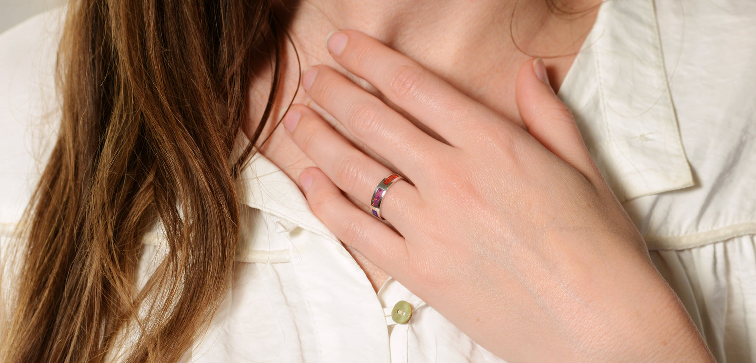 Opals & Ashes Rainbow Unisex Memorial Ring Silver. Ashes blended with Crushed Opals the colours of the rainbow. Lavender and red. Modelled on female hand.