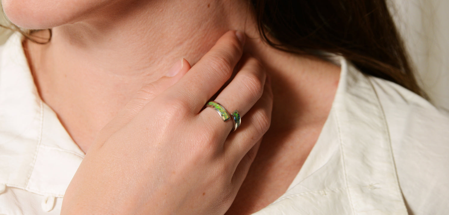 Opals & Ashes Spiral Memorial Ring Silver. Modelled on female hand. Ashes blended with Spring Green Opals.