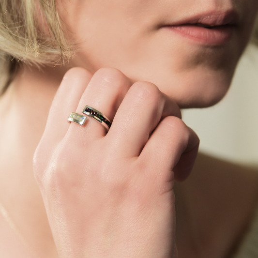 Opals & Ashes Dual Spiral Memorial Ring Silver. Modelled on female hand. Ashes blended with Black Fire and Pearl White Opals.