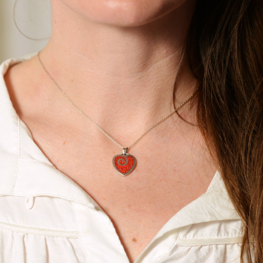 Opals & Ashes Spiral Heart Memorial Pendant Silver. Modelled on female. Ashes blended with Ruby Red Opals.