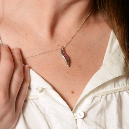 Opals & Ashes Wave Memorial Pendant Silver. Modelled on female. Ashes blended with Lavender Opals.